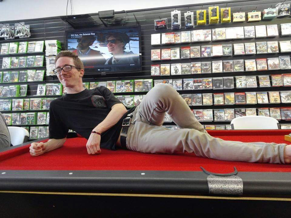 Branton ‘Buddy’ Ramsey smiling while reclining on a pool table, part of the Branton Ramsey Legacy Foundation story honoring his love for technology, gaming, and community.
